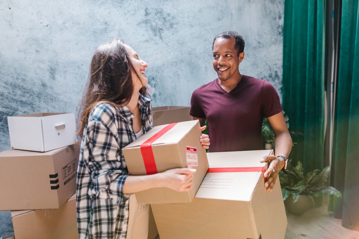 A couple carrying moving boxes together